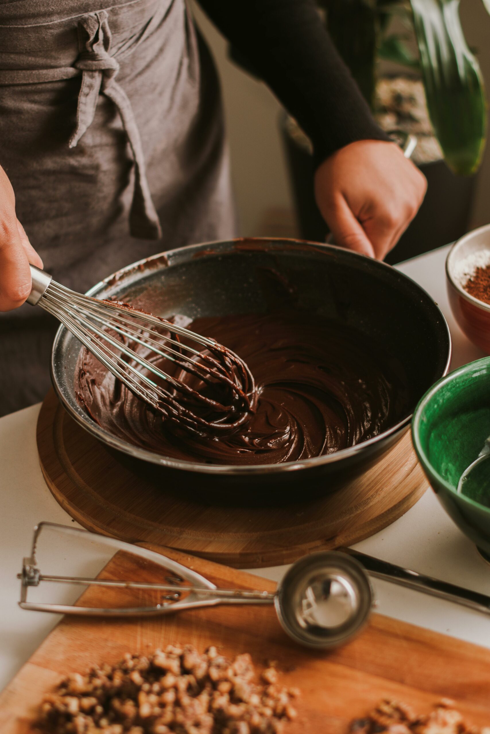 Mulher fazendo têmpera de chocolate com fuê numa bancada